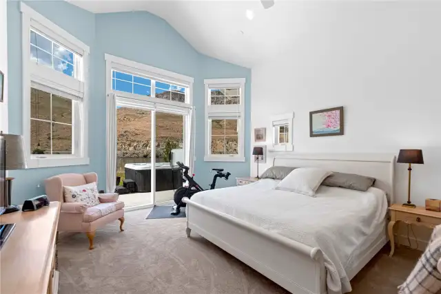View 1 of Primary Bedroom with glass sliding doors leading to the outdoor Columbia River view patio with private hot tub.