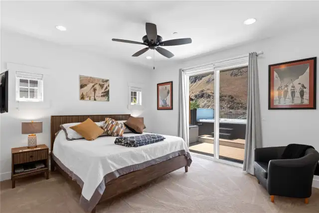 View of Guest Bedroom 1 with glass sliding doors leading to the outdoor living area and swim spa overlooking the Columbia River.