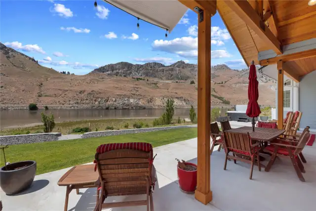 Outdoor Living area with dining and lounge area and private spa overlooking the Columbia River and sandy waterfront beach area.