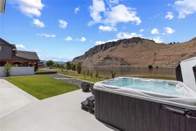 Outdoor Living area with private hot tub and lounge area overlooking the Columbia River and sandy waterfront beach area.