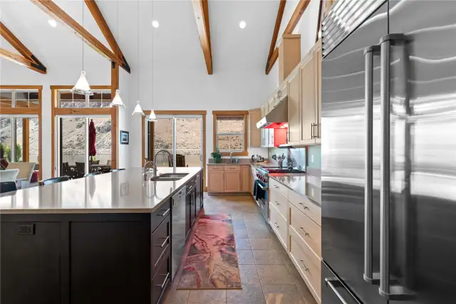 View 1 of Entertainer's kitchen with maple cabinets, quartz countertops, radiant heated tile floors, high-end appliances including a Sub-Zero refrigerator, Wolf range and oven, double Miele/Fisher-Paykel dishwashers, double ovens, 2nd prep sink and coffee bar.