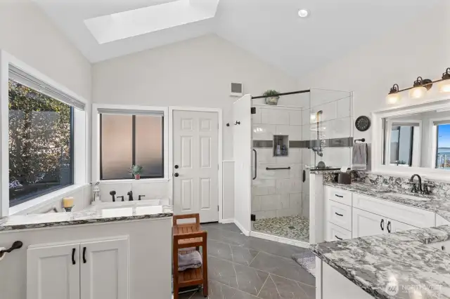 Barn door leads you into the spa like bath with Quartz counters, porcelain tile flooring, and large soaking tub. Skylight and large window faces the views. Beautifully upgraded! Door onto patio.