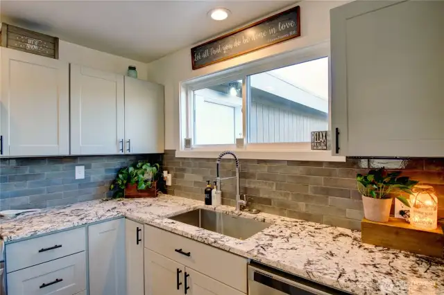 Granite countertops and beautiful tile backsplash.