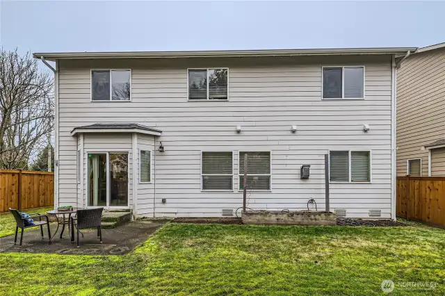 The back of the house in the fully fenced back yard. The patio is off the kitchen and is a great spot for coffee or BBQ's.