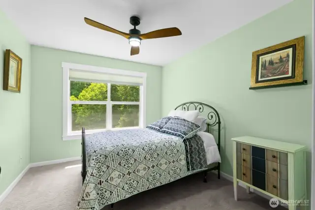 Upstairs guest bedroom one, looks out to the peaceful wooded setting.