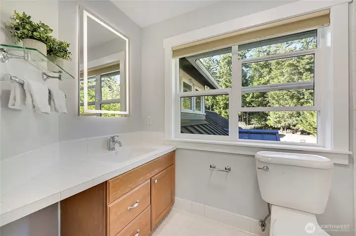 The freshly painted guest bath and newly installed illuminated mirror.