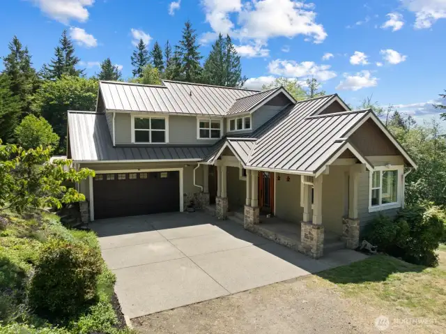 Plenty of parking and the covered porch with stone accents is a classy touch. The metal roof will provide years of maintenance free living.
