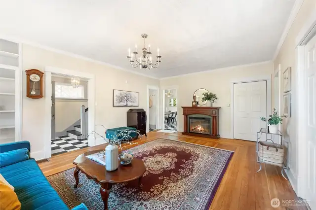 Inviting main living space highlighted by a classic fireplace, tall ceilings, and hardwood floors.