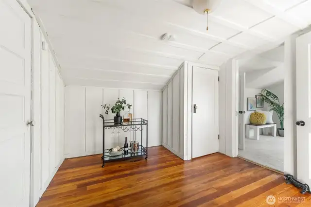Cozy and bright upstairs sitting area with hardwood floors, ideal as a reading nook or flexible space between two bedrooms.
