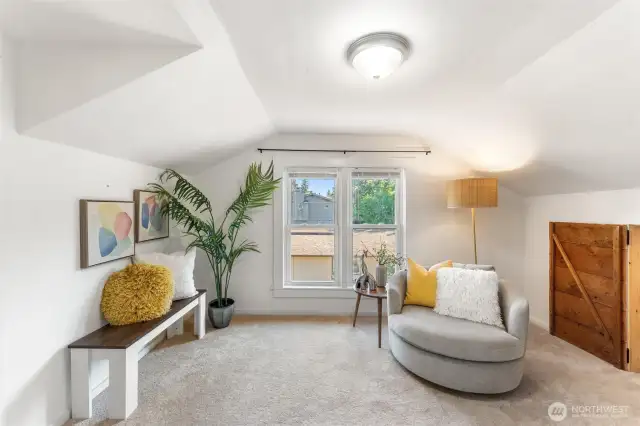 Spacious upstairs bedroom #4 with cozy carpet, natural light, and charming sloped ceilings.