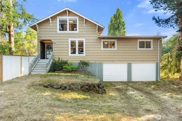 Classic curb appeal! This inviting front view highlights the charming Craftsman-style architecture with its crisp siding, welcoming front steps, and oversized windows that flood the interior with natural light. The two-car garage provides plenty of space for vehicles, storage, or projects, while the elevated entry gives the home a timeless and stately presence.
