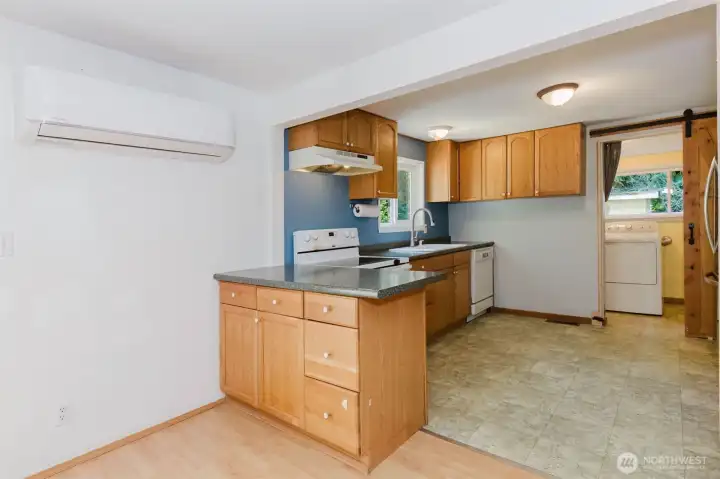Mini Split at one end of the living room near kitchen entrance for heat and air conditioning.