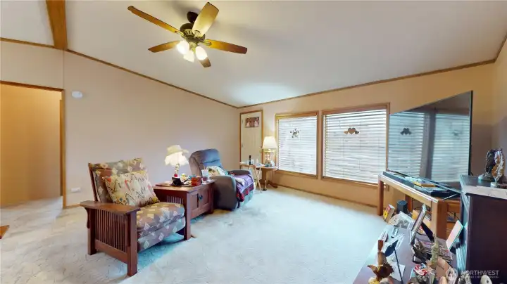 Large windows allow tons of natural light into the room. The doorway leads to two additional rooms and a full bathroom.