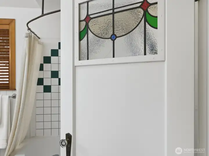 The character of the stained glass carries through on the bathroom door