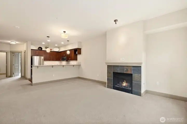 Another angle of the Dining and Living room with gas fireplace and the Kitchen beyond.
