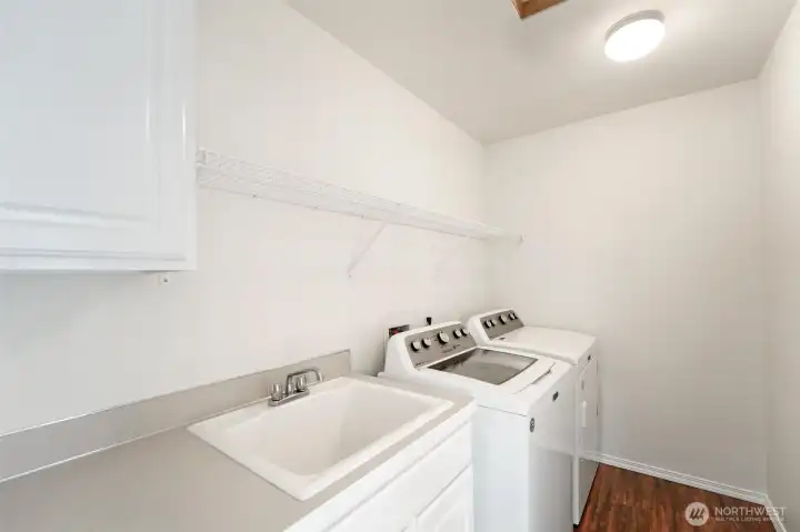 The laundry room complete with sink and storage!
