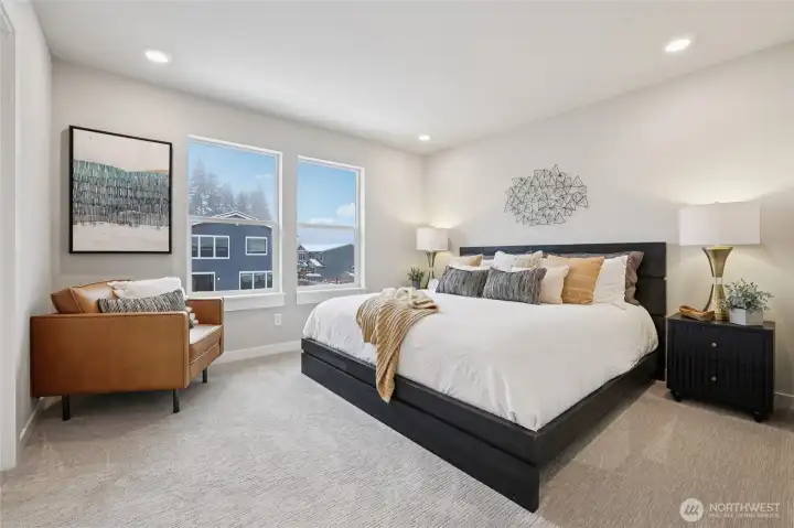 Primary bedroom with king sized bed - showing stage home in the community with the same plan.