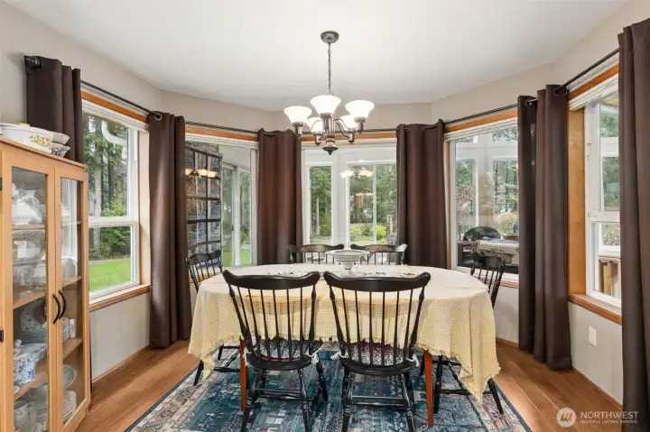 The lovely bay window of this dining nook offers a view through the sun room and into the back yard.