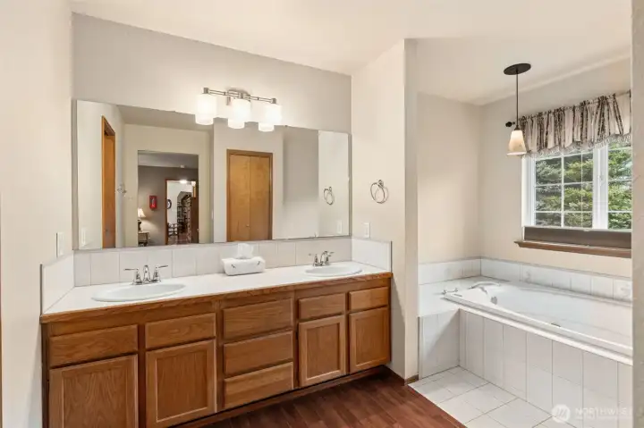 Double sink vanity and jetted soaking tub in the primary ensuite bathroom.