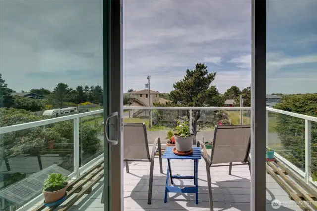 Step out of the living room onto this third story deck to enjoy a gorgeous ocean and sunset view.