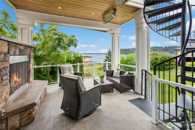 Here is that covered deck, just off the kitchen/nook area. Note the gas fireplace, ceiling heater and circular staircase which leads up to the primary suite's sweeping view deck or down to the lower level covered patio.