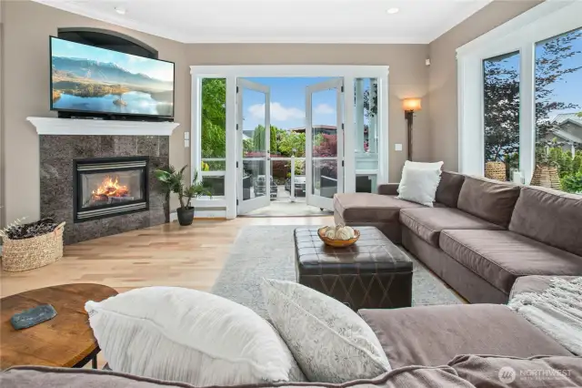 This great room flows from the main floor hallway and is open to the kitchen and nook, making it the perfect space for entertaining. Note the double doors to the balcony, gas fireplace (one of four), and refinished hardwood floors.