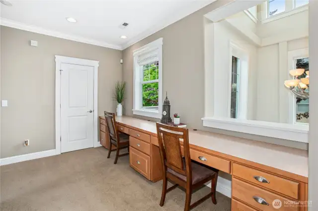 On the upper level is this convenient desk area for two with great storage and abundant natural light.