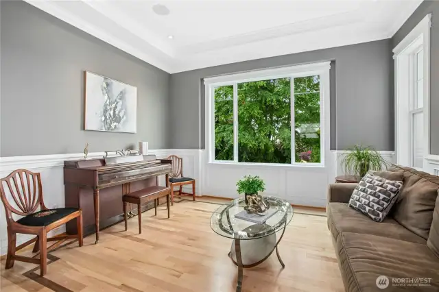 The living room is adjacent to the kitchen and features beautiful crown molding and refinished hardwood flooring.