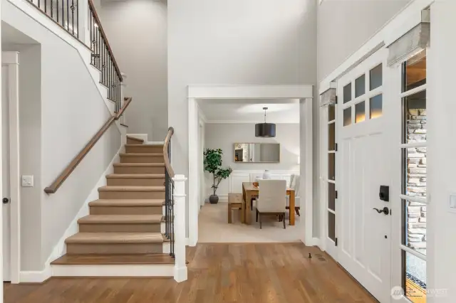 Welcoming entry with vaulted ceilings, open balcony, and bright interior.