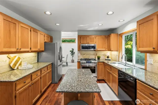 Open Concept kitchen with island, granite counter tops, under cabinet lighting and the gorgeous hardwood floors