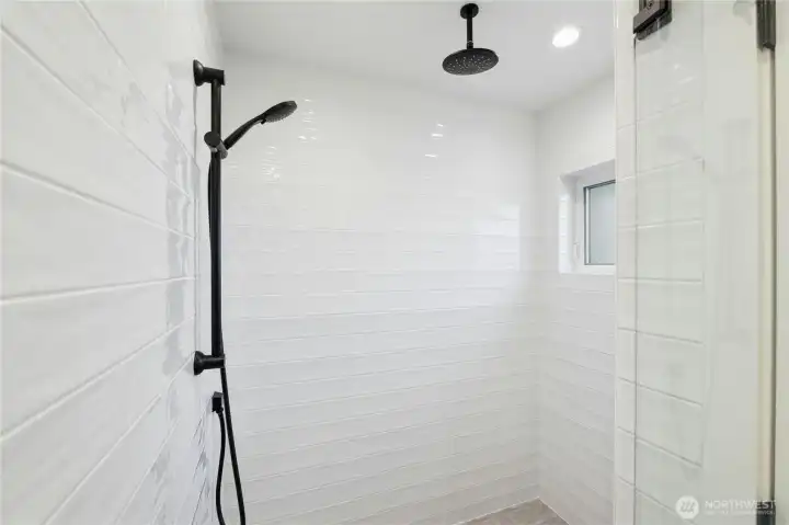 Large walk-in shower features rain shower head and handheld combo, making getting clean enjoyable!