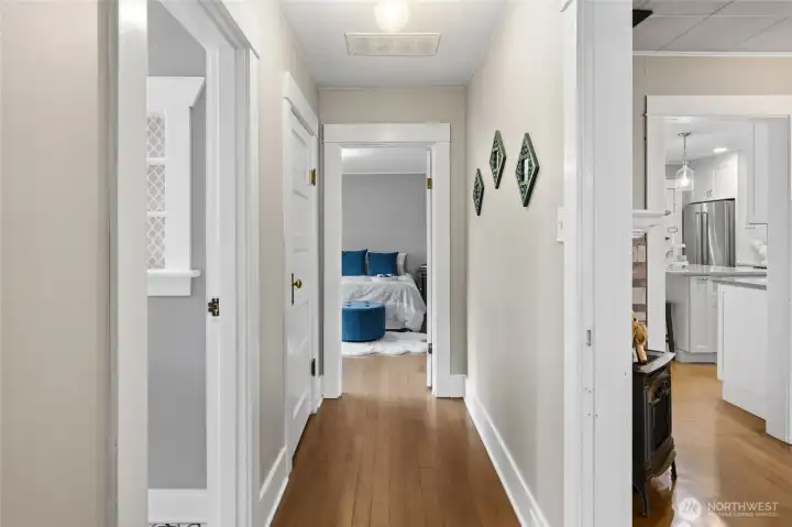 Hallway looking into Guest Bathroom and Primary Bedroom. Love these original fir floors!