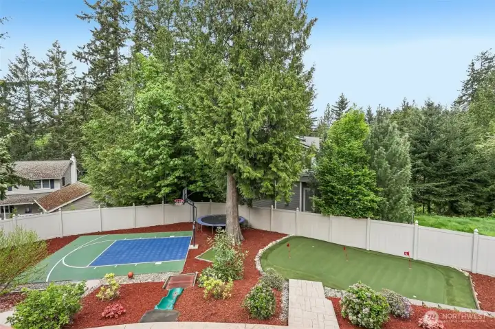 Check out this incredible backyard featuring a basketball court, trampoline, mini golf and putting green — a true dream setting for sports enthusiasts and year-round outdoor entertaining!