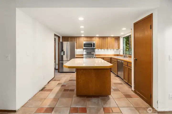 Kitchen with large island and stainless steel appliances.