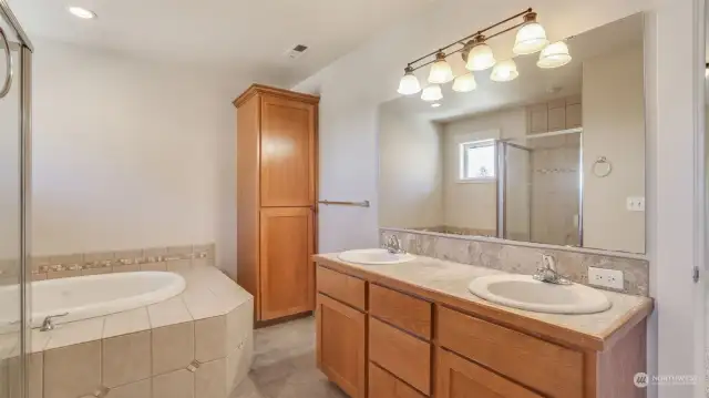 En-suite bathroom has tons of storage and warm color palette.