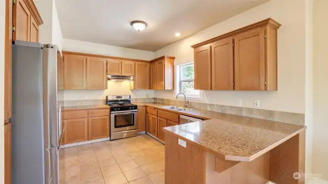Entertaining made easy in this open kitchen that features Stainless Steel appliances, warm cabinetry & walk-in pantry.