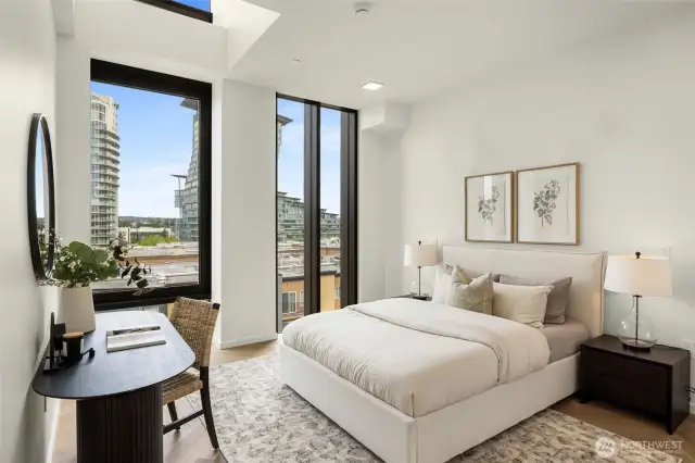 Primary bedroom features floor-to-ceiling windows, chevron engineered white oak floors and a walk-in-closet.