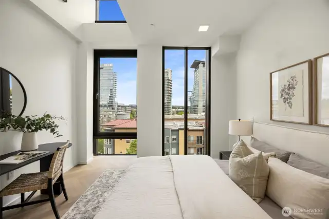 Primary bedroom features floor-to-ceiling windows, chevron engineered white oak floors and a walk-in-closet.