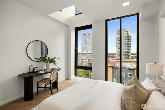 Primary bedroom features floor-to-ceiling windows, chevron engineered white oak floors and a walk-in-closet.