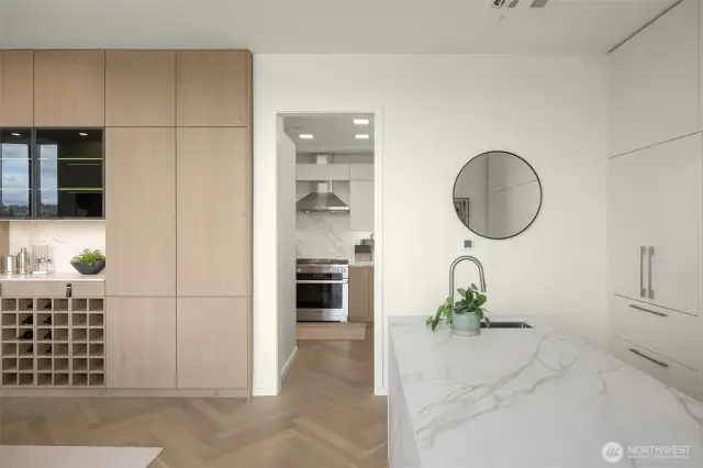 High-end custom cabinetry features Bavaria Oak wood veneer, custom wine storage, lighting and push-to-open cabinets