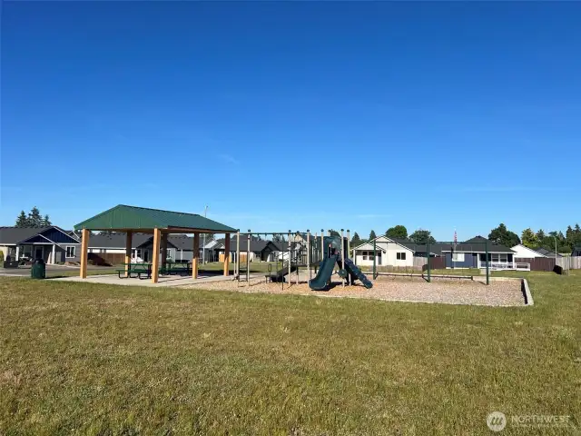 Private community park with covered picnic area, playground set, and swings.