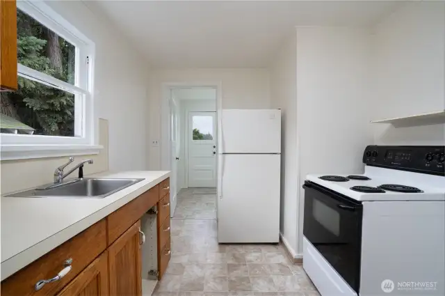 Kitchen features new linoleum and fresh paint. Kitchen appliances stay. (Owner is having a replacement cabinet door made to match)
