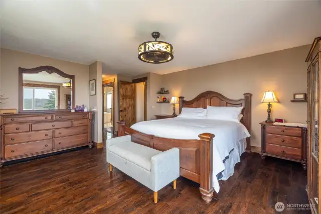 Primary bedroom on main floor with private deck and bath beyond, view view view.