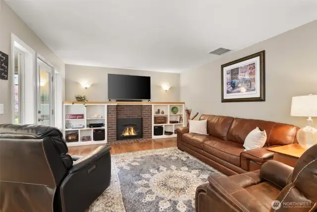 Family room with gas fireplace, refinished hardwoods and walk out with a screen door to large outdoor living space.
