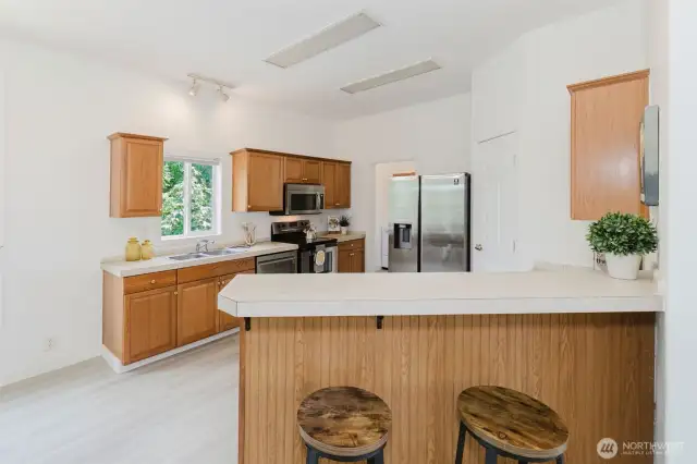 Bright kitchen with ample cabinetry and laminate flooring throughout.