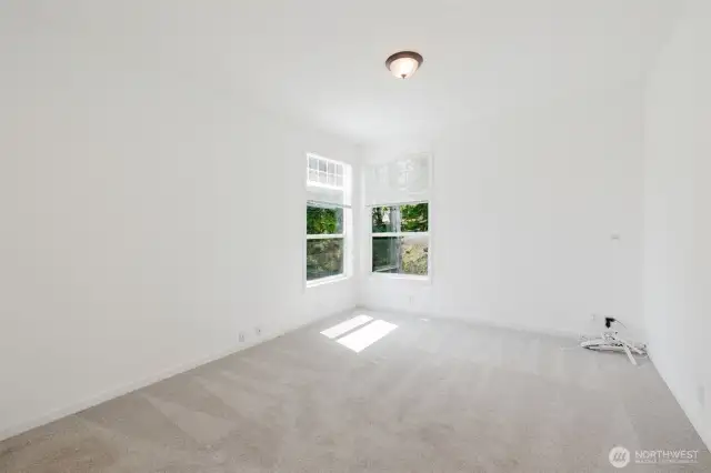 Comfortable bedrooms with carpet flooring and large windows for natural light.