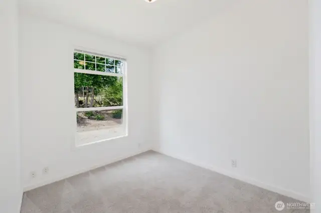 Secondary bedrooms with neutral finishes and carpet flooring.