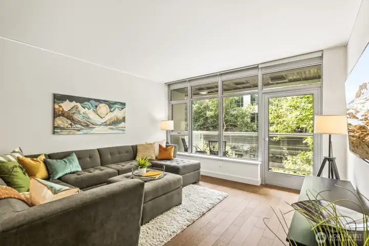Floor-to-ceiling windows and a private covered deck that extends the living space.