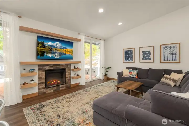 Custom raw hemlock mantel and shelves frame the living room fireplace, creating a warm, rustic focal point.