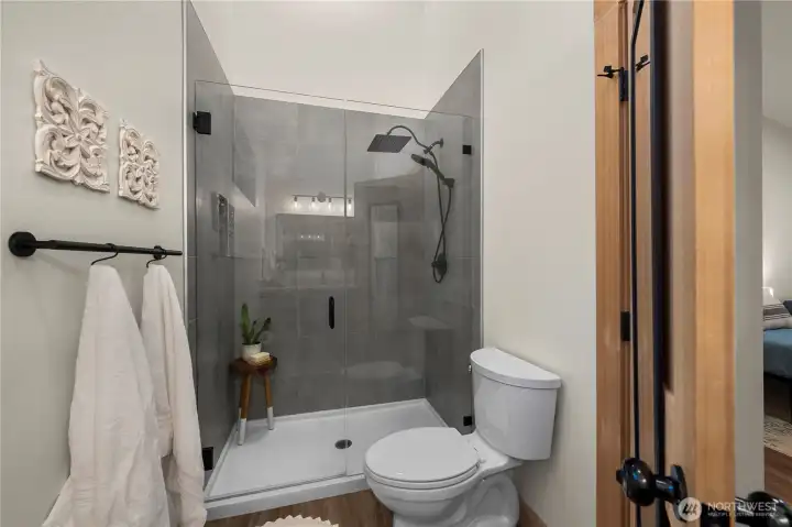 Serene spa-like shower in the primary suite with newly installed rainfall showerhead and sprayer.